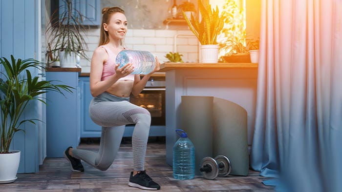 Woman working out with water bottles