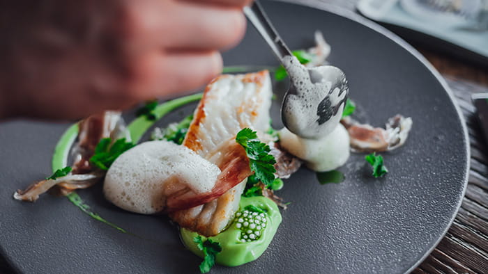 A fine dining dish of fish, foam, and caviar.