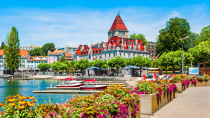 A serene view of Lake Geneva with the majestic Alps in the background.