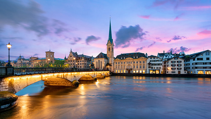 A serene view of Lake Zürich with the city's picturesque skyline in the background.